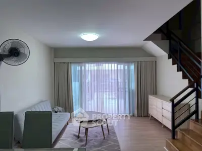 Spacious living room with modern furniture and large windows for natural light.