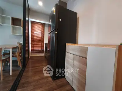 Modern kitchen with sleek black fridge and wooden dining set