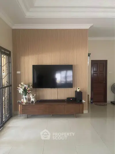 Modern living room with sleek TV setup and elegant decor, showcasing contemporary interior design.