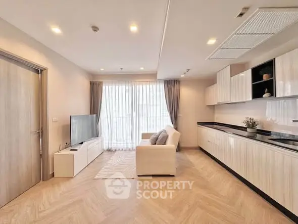Spacious modern living room with sleek kitchen and natural light