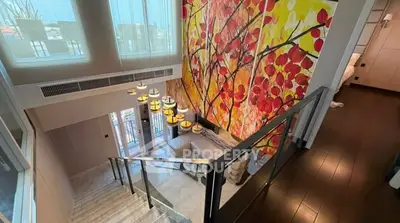 Stunning duplex interior with vibrant wall art and modern staircase, offering a luxurious living experience.