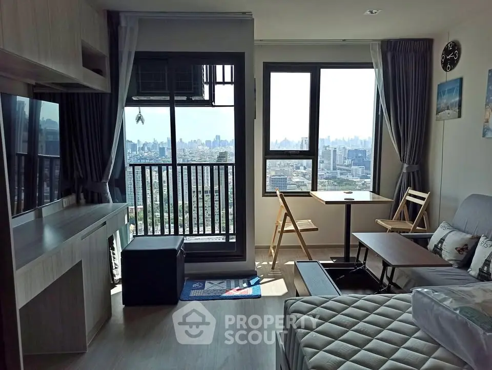 Modern living room with city view, featuring large windows and stylish furniture in a high-rise apartment.