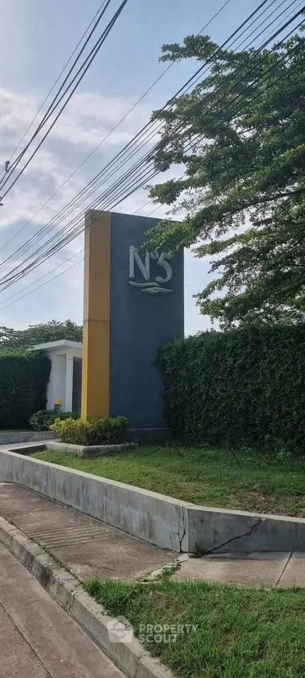 Modern entrance sign with lush greenery in a residential community.