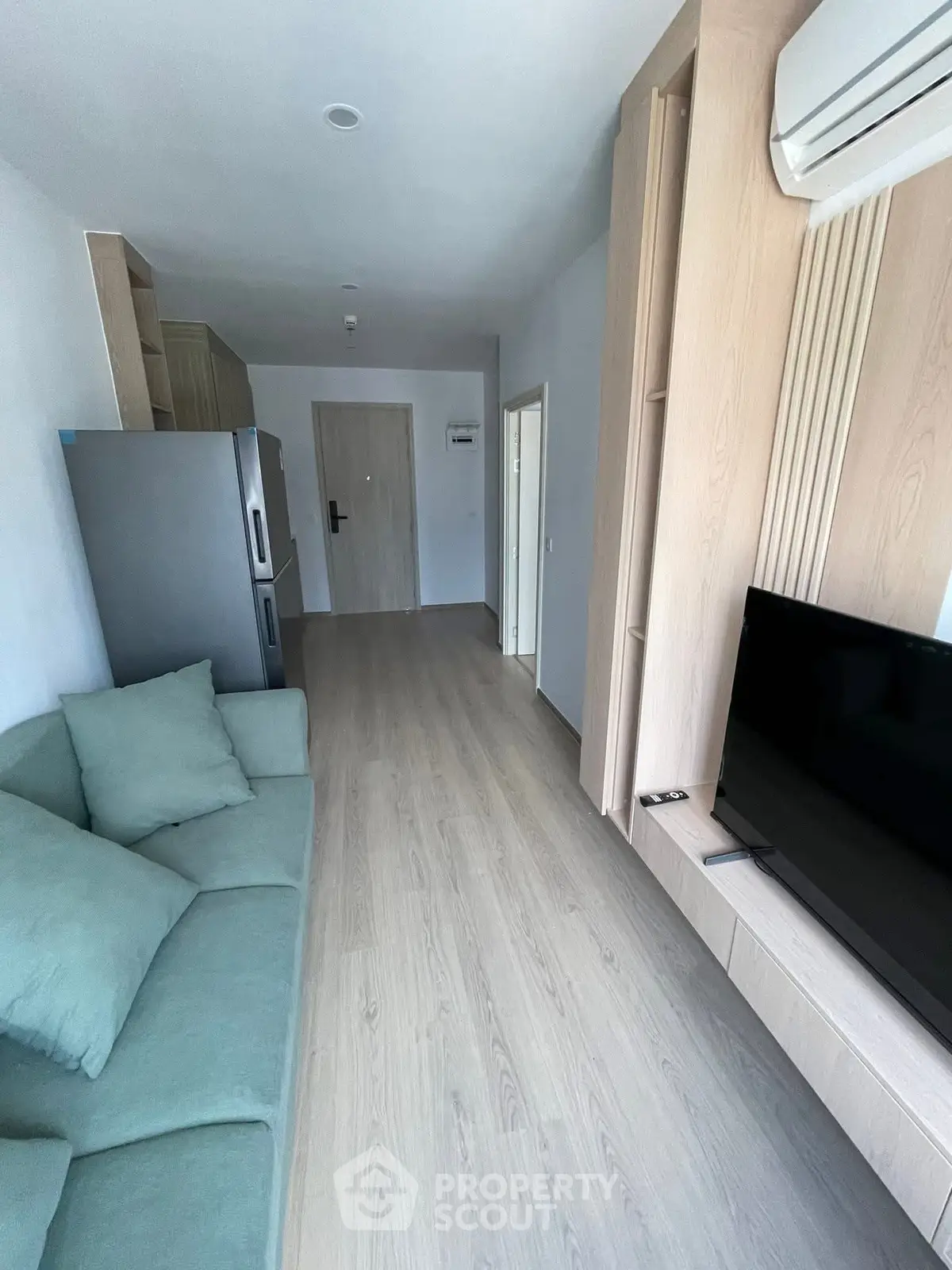 Modern living room with sleek design, featuring a comfortable sofa and flat-screen TV, perfect for relaxation.