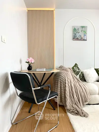 Cozy living room corner with modern chair, small table, and plush sofa in stylish decor.
