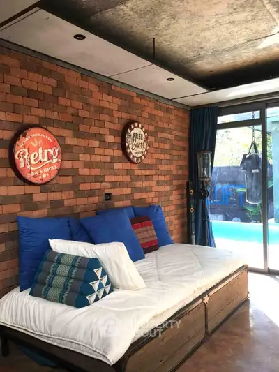 Stylish living room with brick wall and pool view, featuring retro decor and cozy seating.