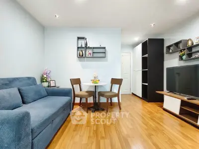 Charming living room with cozy blue sofa and modern decor, perfect for relaxation and entertainment.