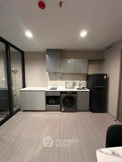 Modern kitchen with sleek appliances and stylish cabinetry in a contemporary apartment.