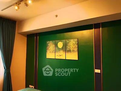 Stylish bedroom with green accent wall and modern lighting