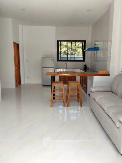 Modern open kitchen with sleek design and cozy seating area, perfect for entertaining.