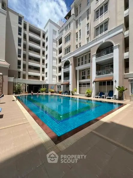 Luxurious apartment complex with a stunning outdoor pool and modern architecture.