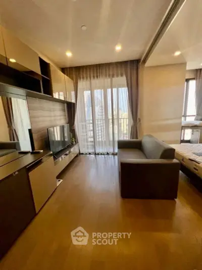 Modern living room with large windows and stylish furniture in a cozy apartment.