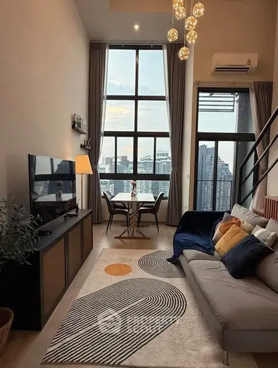 Stylish modern living room with high ceilings and city view, featuring chic decor and large windows.