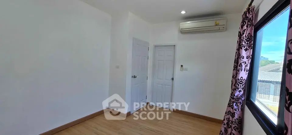 Bright empty room with air conditioning and large window, perfect for customization.