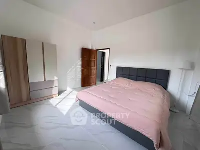 Spacious bedroom with modern furnishings and natural light