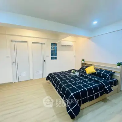 Spacious modern bedroom with stylish decor and ample natural light