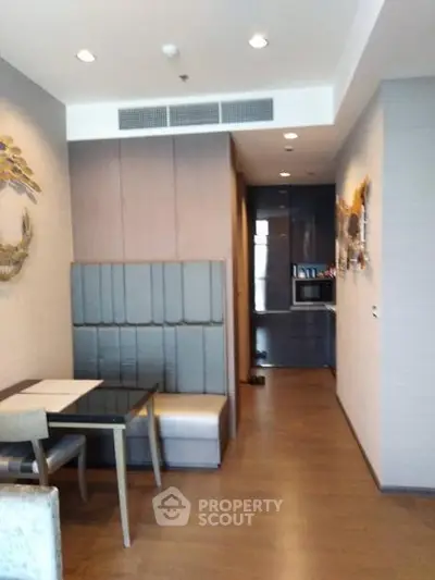Modern dining area with built-in seating and sleek kitchen in a stylish apartment.