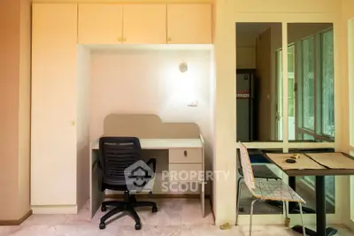 Modern study area with desk and chair in a well-lit room, featuring built-in storage and sleek design.