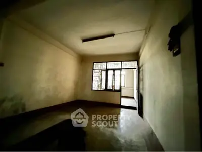 Spacious empty room with large window and natural light, ideal for customization.