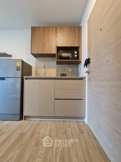 Modern compact kitchen with wooden cabinets and sleek appliances