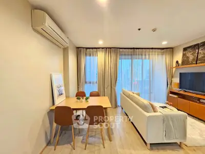 Modern living room with dining area and city view, featuring sleek furniture and ambient lighting.