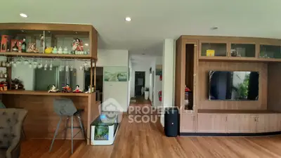 Spacious living room with modern wooden cabinetry and bar area