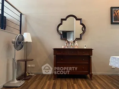Charming interior with elegant wooden dresser and decorative mirror in cozy living space.