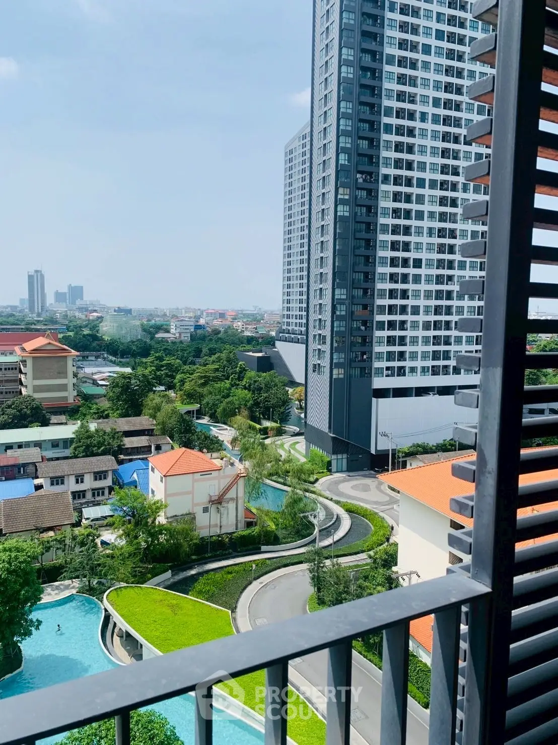 Stunning high-rise building with lush green surroundings and pool view.