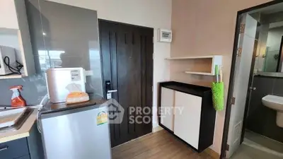 Compact kitchen area with modern appliances and bathroom access