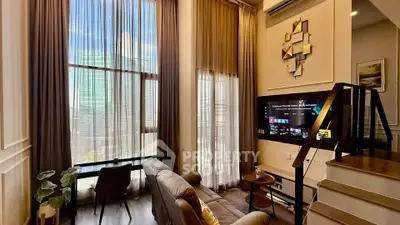 Luxurious modern living room with high ceilings and city view, featuring stylish decor and natural light.