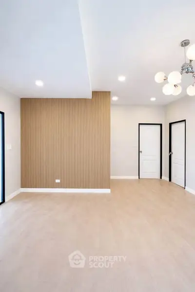 Spacious modern living room with elegant lighting and wood accent wall