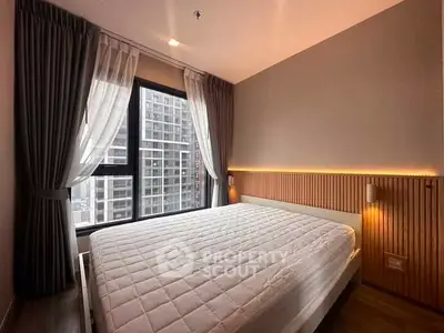 Modern bedroom with large window and stylish lighting in urban apartment.