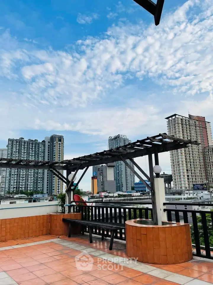 Stunning rooftop terrace with city skyline views and pergola seating area.
