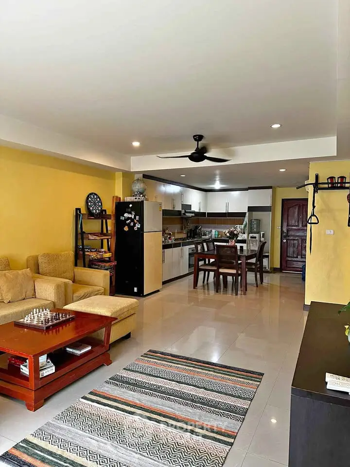 Spacious open-layout living room with modern kitchen and cozy seating area.