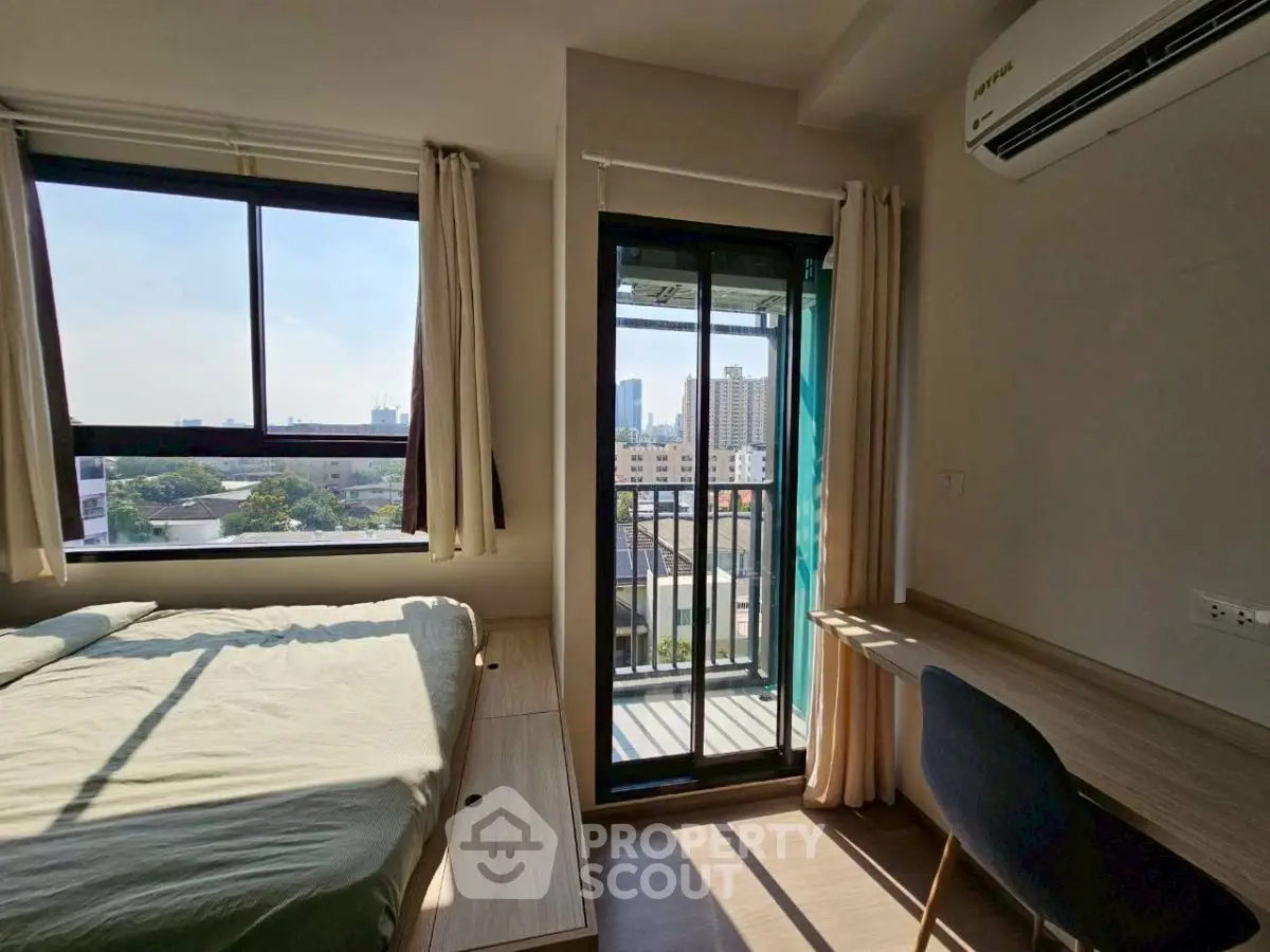 Cozy bedroom with balcony view and natural light in modern apartment.