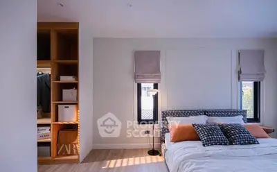 Modern bedroom with stylish decor and natural light, featuring a cozy bed and built-in storage.