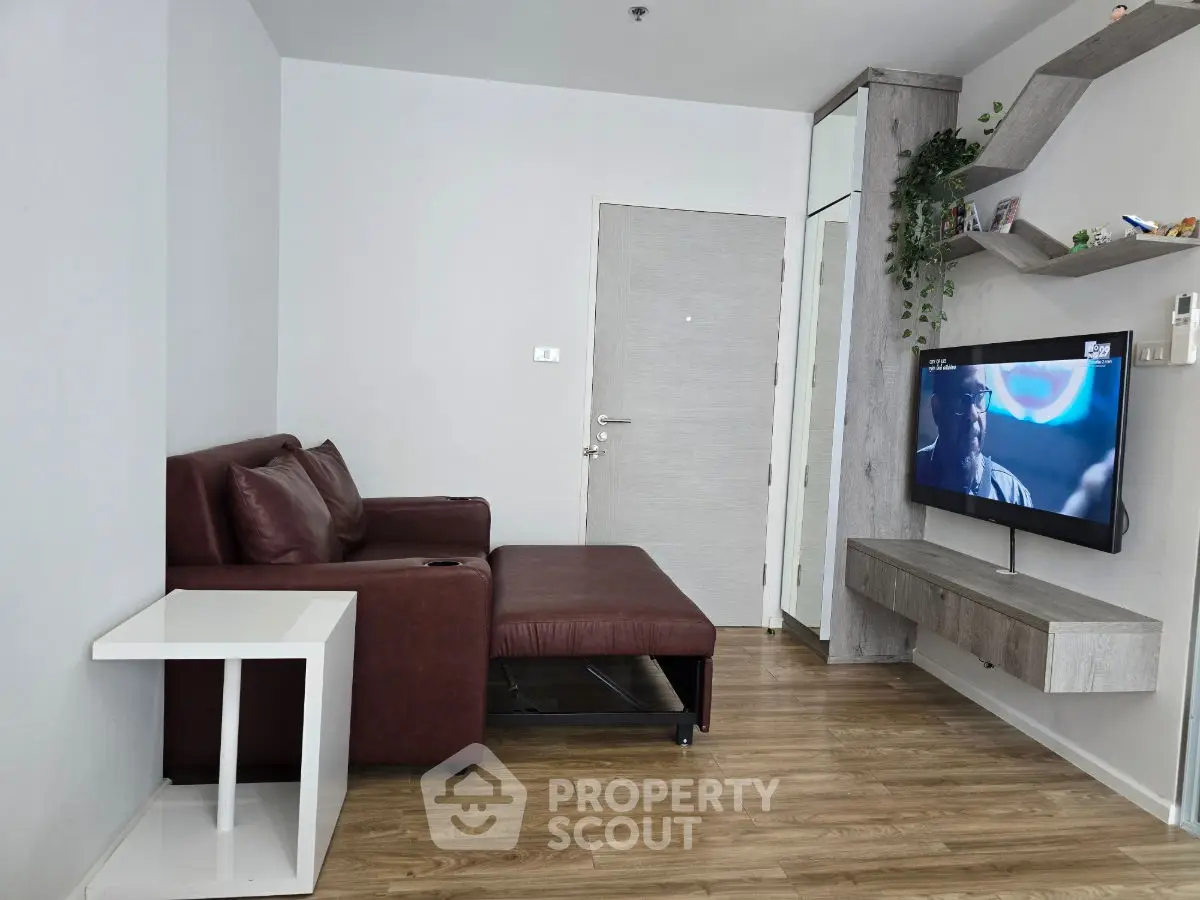 Modern living room with sleek furniture and mounted TV, showcasing contemporary design and cozy ambiance.