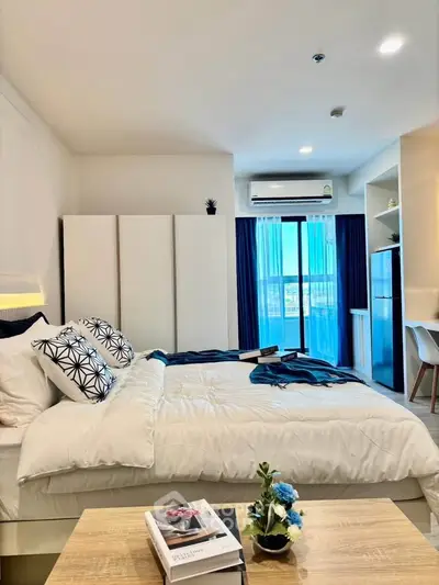 Modern bedroom with stylish decor and natural light, featuring a cozy bed and elegant furnishings.