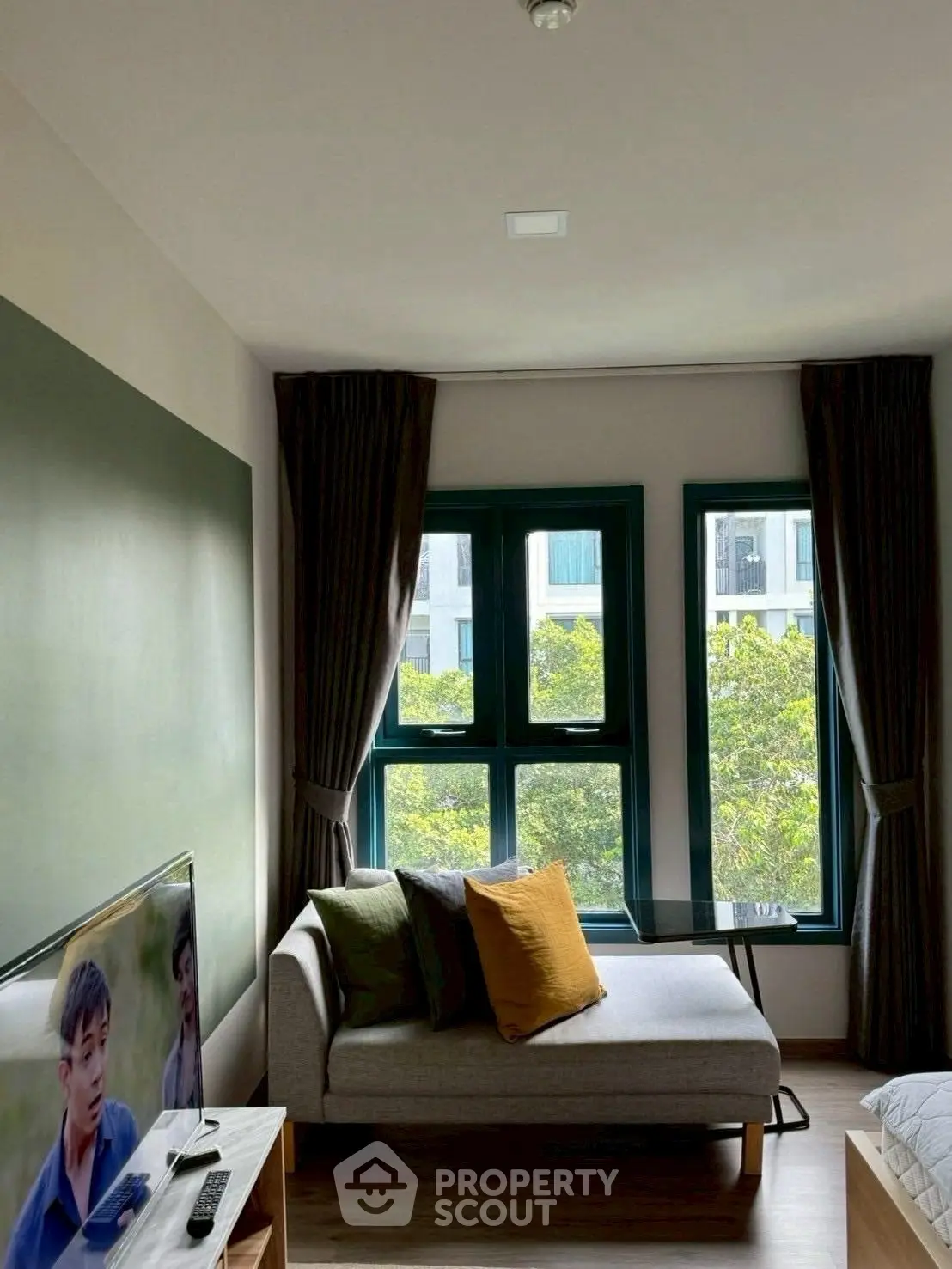 Cozy living room with modern decor and natural light from large windows.