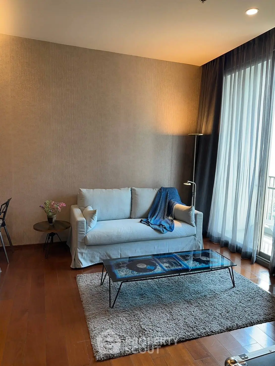 Modern living room with cozy sofa and glass coffee table in elegant apartment