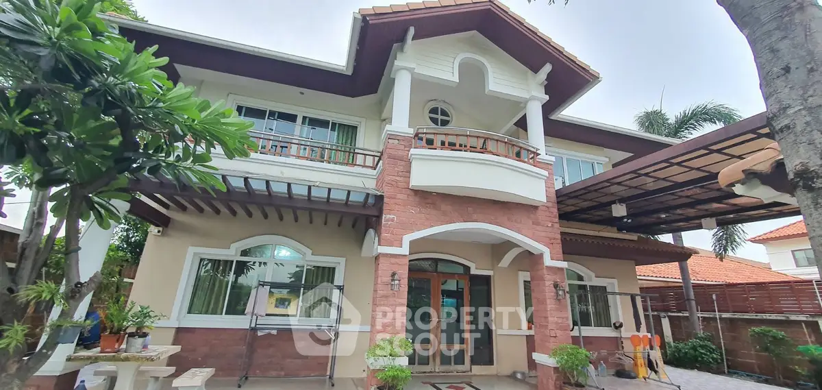 Stunning two-story house with elegant facade and lush greenery, perfect for family living.