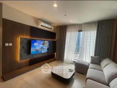 Modern living room with sleek design, featuring a wall-mounted TV, stylish sofa, and large window with city view.