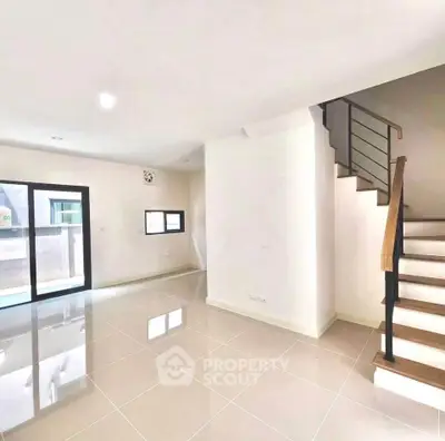 Spacious modern living room with staircase and large windows