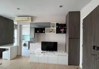 Modern living room with built-in TV unit and washing machine, showcasing sleek design and functionality.