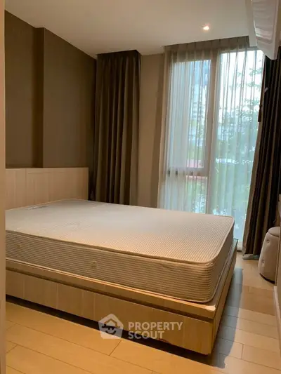 Cozy bedroom with large window and modern decor in a stylish apartment.