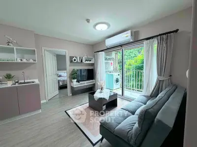 Modern living room with balcony and washing machine, featuring sleek furniture and natural light.