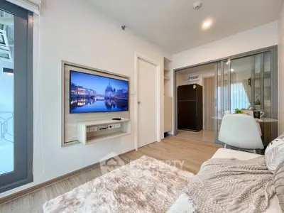 Modern living room with wall-mounted TV and cozy decor in a stylish apartment.