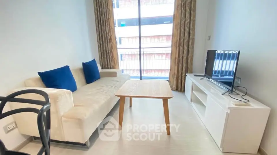 Modern living room with cozy sofa, TV, and large window in a stylish apartment.