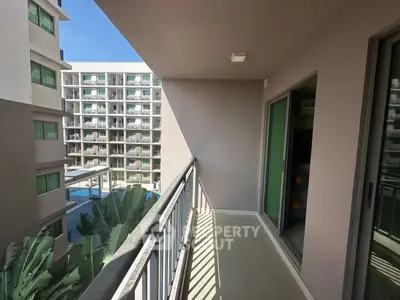 Spacious balcony with pool view in modern apartment complex