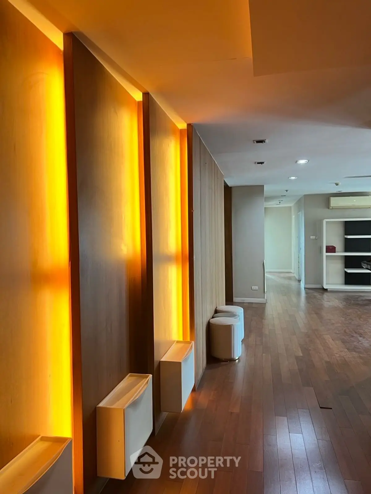 Spacious modern interior with warm lighting and wooden flooring, perfect for stylish living.